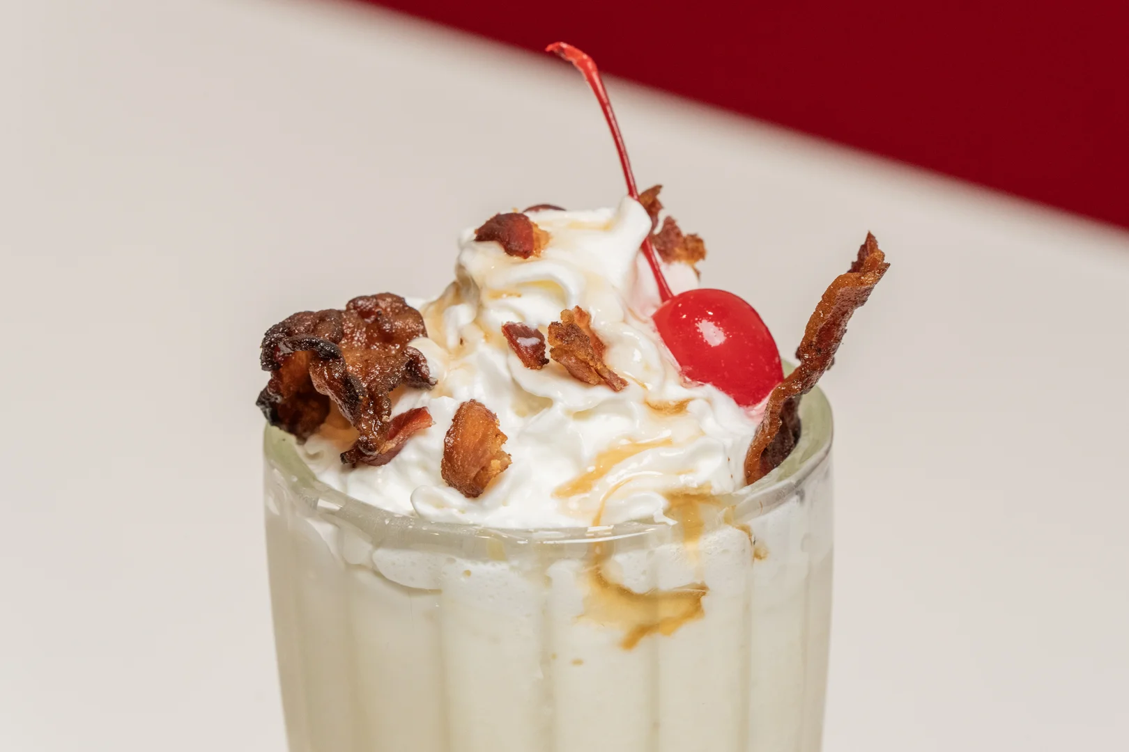 a milkshake with whipped cream and a cherry on top